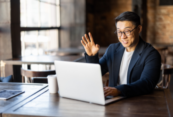 Man waving at laptop.